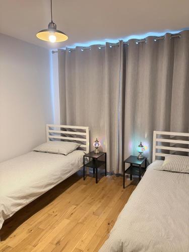 two beds in a room with two tables at Double en-suite in Glin