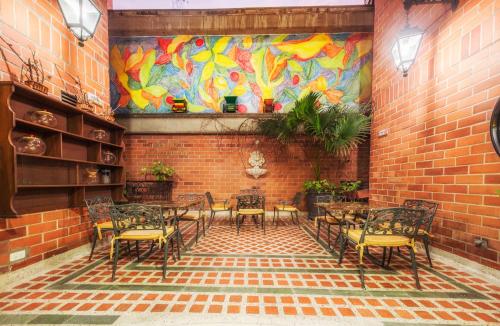 a room with a table and chairs and a mural at Hotel San Pedro del Fuerte in Medellín