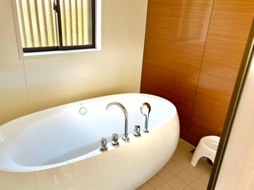 a bath tub with a faucet in a bathroom at 結良house in Yura