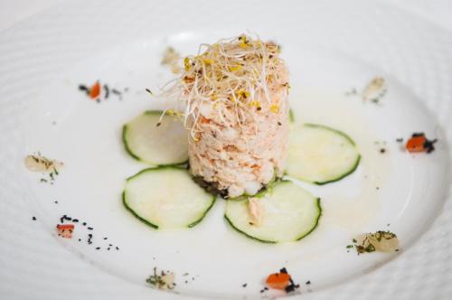 a plate of food with some rice and cucumbers at Hotel Rural Biniarroca - Adults Only in Sant Lluis