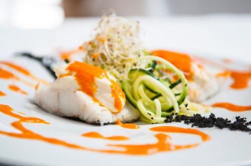 a plate of food with sushi and vegetables on it at Hotel Rural Biniarroca - Adults Only in Sant Lluis