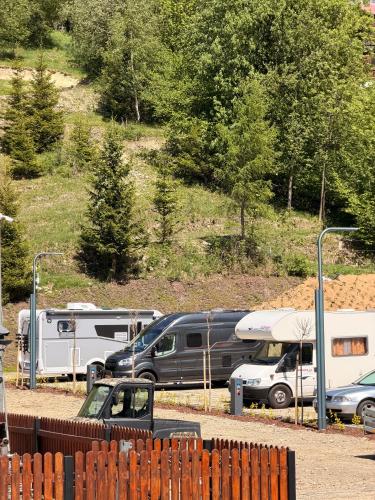 a group of vehicles parked in a parking lot at Kamper Park Babia Góra - parcele kamperowe in Zawoja