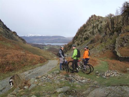 three people standing on a hill with their bikes at Woodside B&B in Keswick