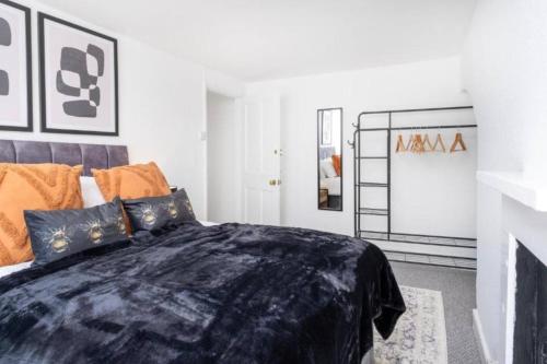 a bedroom with a bed with a black blanket at Central Stroud 3-Bedroom Flat with Fast WiFi in Stroud