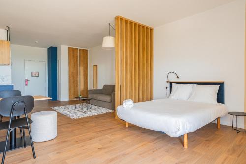a bedroom with a bed and a living room at ECLA Genève Archamps in Archamps