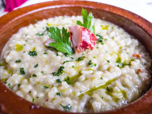 a bowl of risotto with a green leaf on top at Hotel Rural Biniarroca - Adults Only in Sant Lluis