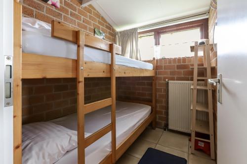 a room with two bunk beds and a door at Rekerlanden 187 in Schoorldam