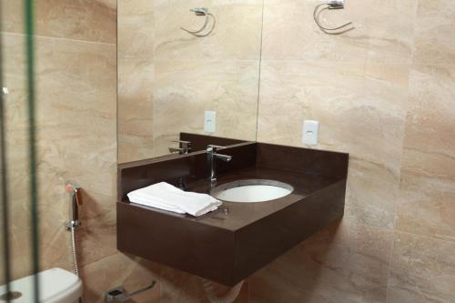 a bathroom with a sink and a mirror at Pousada Villa Ricca Park in Niquelândia