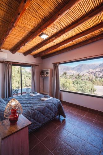 a bedroom with a bed and a large window at La Llama Negra in Tilcara