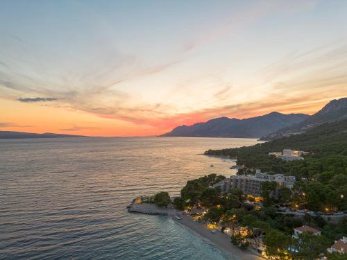 an island in the middle of the water at sunset at Bluesun Hotel Soline in Brela