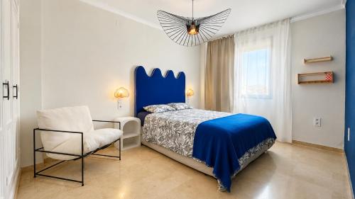 a bedroom with a blue bed and a chair at Casa Lovely in Daimuz