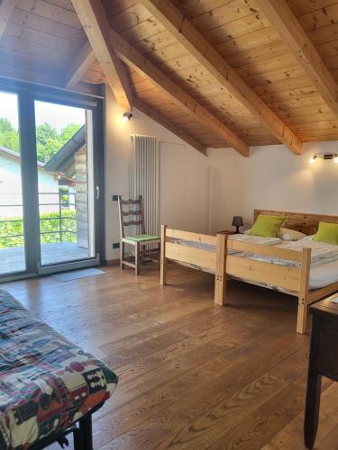 a bedroom with two beds and a large window at B&B Le Colombine in Abbadia Lariana