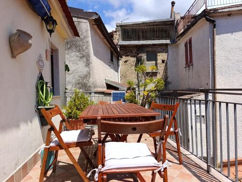 a patio with a wooden table and chairs on a balcony at Iris in Rodio