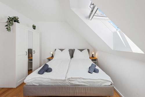 a white bedroom with a bed with two pillows at Stiftblick Residence Melk in Melk