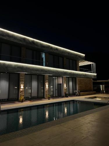 a building with a swimming pool at night at Green Vista in Māḩiş