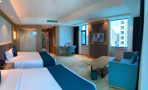 a hotel room with two beds and a table and chairs at SENNA SUNSHINE INTERNATIONAL HOTEL in Sihanoukville