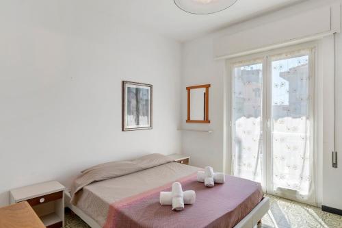 a bedroom with a bed with two white towels at Isonzo Holiday Home - 2 bedrooms in Loano