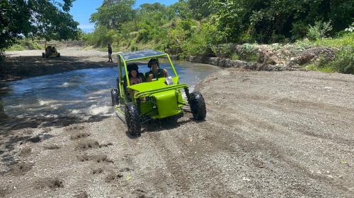 ein grünes Quad, das eine unbefestigte Straße entlangfährt in der Unterkunft Frailin Merete in San Felipe de Puerto Plata