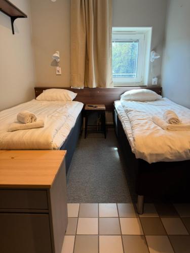 two beds in a room with a window at Uncle Joe's in Visby