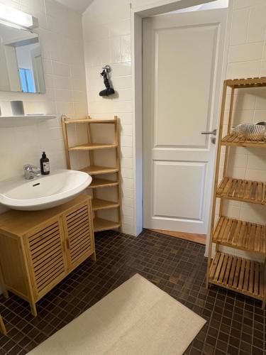 a bathroom with a sink and a white door at Ferienwohnung Fortuna in Borkum