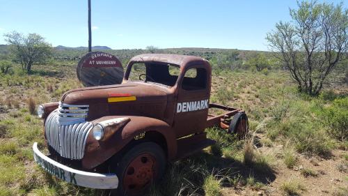 an old truck sitting in the middle of a field at Denmark Farm Stay in Cradock