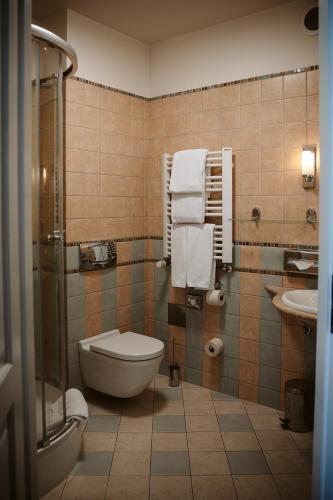 a bathroom with a toilet and a sink with towels at Hotel Senacki in Krakow