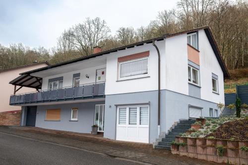 a white house with a balcony on a street at Ferienwohnung Felsenidyll in Bundenthal