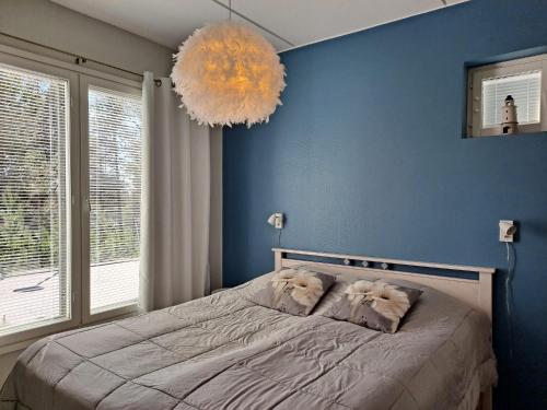 a bedroom with a bed with a blue wall at Seastar 101 in Kalajoki
