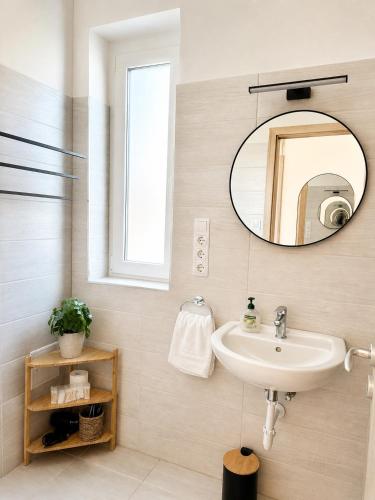a bathroom with a sink and a mirror at Small Garden Apartman in Sárvár