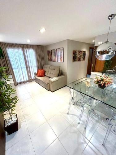 a living room with a glass table and a couch at Apto Garcia 01 ao lado do Shopping Pantanal in Cuiabá