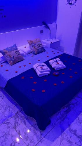 a bedroom with a large bed with purple lighting at K&A Luxury Apartment in Anzio