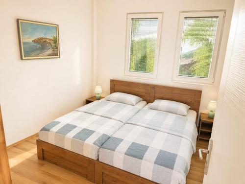 a bedroom with a bed and two windows at Lake and Mountain Hideaway in Ohrid