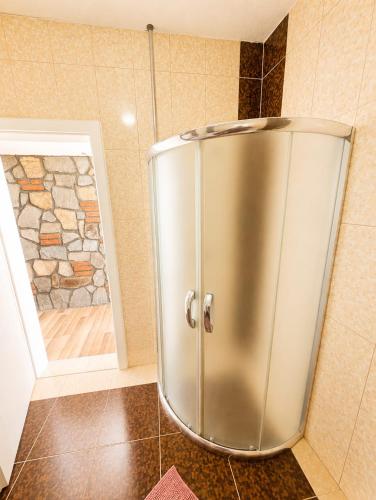 a stainless steel shower in a bathroom with a stone wall at Lake and Mountain Hideaway in Ohrid