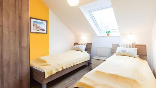 two beds in a small room with a window at Haus an der Pferdekoppel Nr 2 in Fehmarn