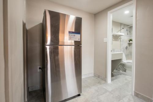a stainless steel refrigerator in a room with a bathroom at Carolina Inn Anderson Clemson Area in Anderson