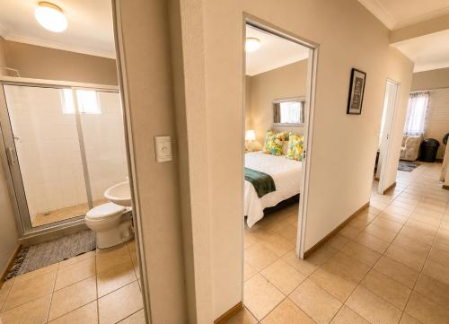a bedroom with a bed and a bathroom with a toilet at Zhantique Guest House 2- Unit 12 in Boksburg