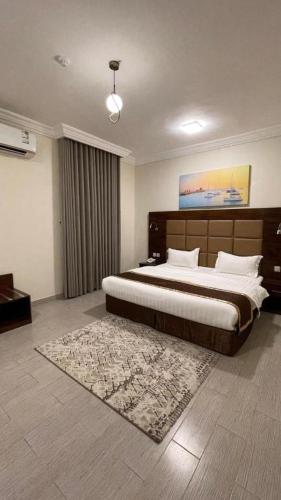 a bedroom with a large bed and a rug at فندق فاتوران فرع ينبع in Yanbu