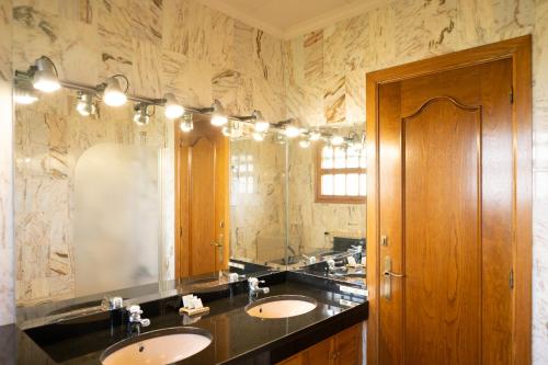 a bathroom with two sinks and a large mirror at Majordoms Vila in Cornellá de Terri