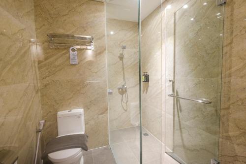 a bathroom with a glass shower with a toilet at Gosyen Azana Hotel Salatiga in Salatiga