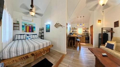 a bedroom with a bed and a living room at The Blue Bahia Resort In Sandy Bay in Coxen Hole