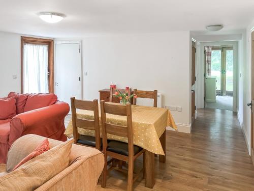a living room with a table and a couch at The Old Sawmill One - Uk49336 in Plumpton Green