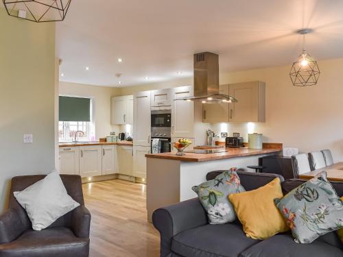 a living room with two couches and a kitchen at The Garth in Helmsley