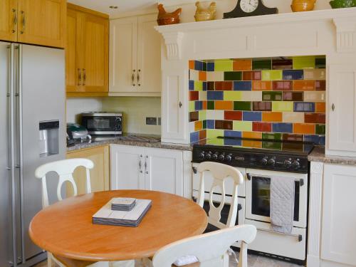 a kitchen with a wooden table and chairs in it at Boothby Cottage in Willoughby