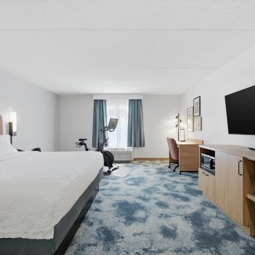 a hotel room with a bed and a flat screen tv at Hampton Inn Inwood in Inwood