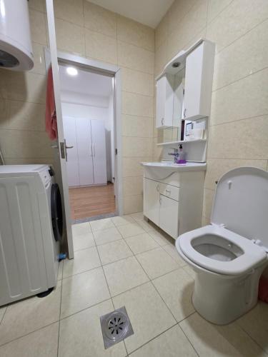 a bathroom with a white toilet and a sink at Apartment 2 Plisi Gjilan in Gnjilane