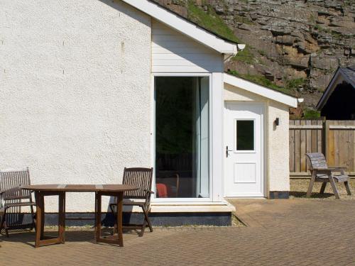 a table and chairs sitting outside of a house at Watersreach in Collieston
