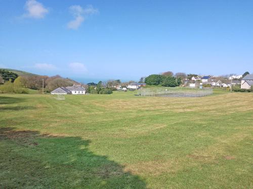 a large field of grass with houses in the background at Lodge 33 in Woolacombe