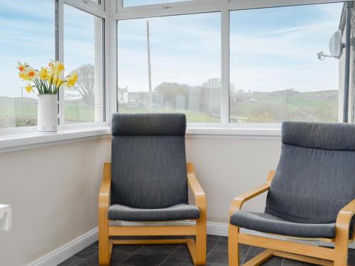 two chairs sitting in a room with windows at Broughton in Newton Stewart