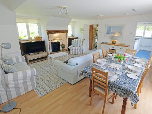 a kitchen and living room with a table and chairs at Clock Cottage in Branscombe
