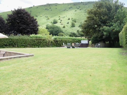 a large lawn with two chairs and a hill in the background at Herrock View in Evenjobb